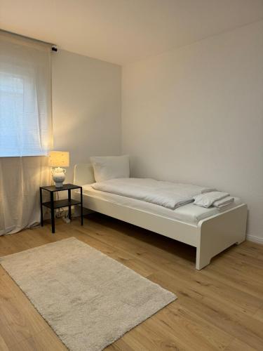 um quarto branco com uma cama e uma mesa em WW02 - Businessapartment Koblenz em Koblenz