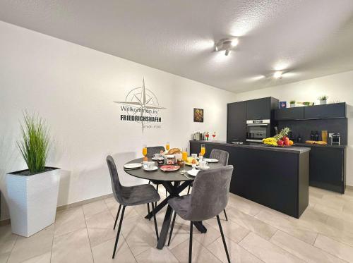 a dining room with a table and chairs in a kitchen at Auszeit Apartment EMOTION in Friedrichshafen