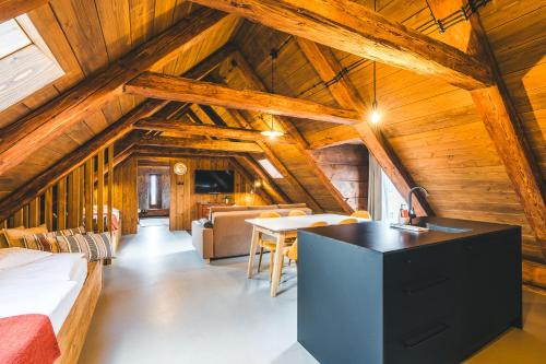 a kitchen and living room in a cabin with wooden ceilings at Aparthotel & Wellness Knížecí cesta in Horní Planá