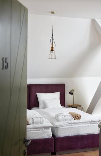 a bedroom with a bed with white sheets at Hercegasszony Birtok in Mezőtúr