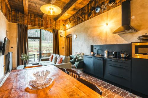 a kitchen and dining room with a wooden table at Aparthotel & Wellness Knížecí cesta in Horní Planá