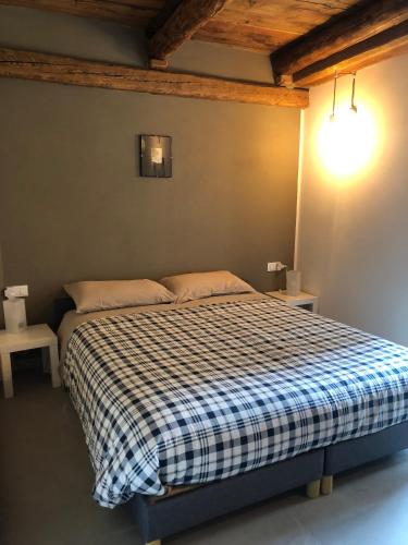 a bedroom with a bed with a checkered blanket at Cicapuy in Puys