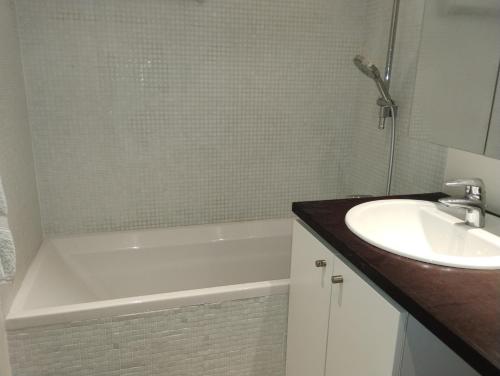 une salle de bain avec une baignoire blanche et un lavabo dans l'établissement Alaris, à Enchastrayes