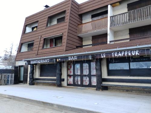 un grand bâtiment avec un panneau indiquant un bar dans l'établissement Alaris, à Enchastrayes