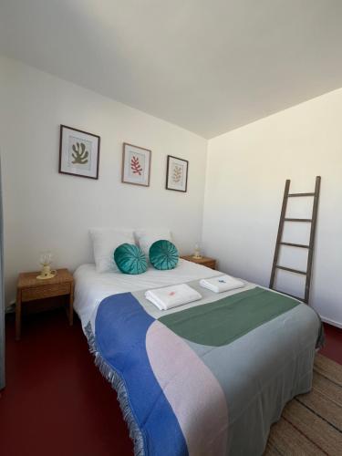 Un dormitorio con una cama grande con almohadas azules y una escalera. en La Perle des Falaises, en Le Tréport