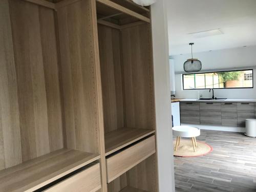 une cuisine avec des placards en bois dans une pièce dans l'établissement Guest House avec piscine et jardin Privatifs, à Le Pian-Médoc