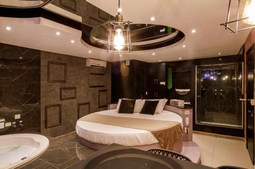 a bedroom with a bed and a tub and a sink at Motel Paradiso - Panambi-RS in Tabapira