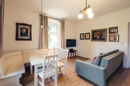a living room with a couch and a table at Aparthotel & Wellness Knížecí cesta in Horní Planá