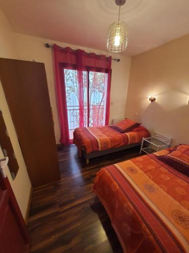 une chambre avec deux lits et une fenêtre dans l'établissement Le Voisin Toulousain 2, à Toulouse