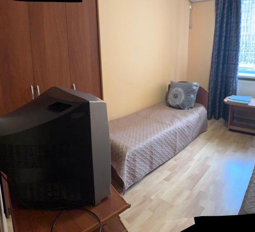 a living room with a television and a bed at Готель "Український Дворик" in Lviv