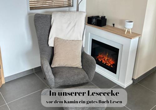 a living room with a chair and a fireplace at Ferienwohnungen Im Kimmelreich in Irsch