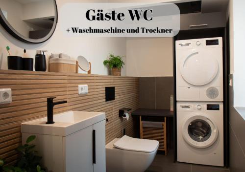 a bathroom with a washing machine and a sink at Ferienwohnungen Im Kimmelreich in Irsch