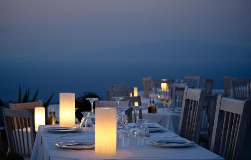 a table with candles and plates and glasses on at Finikia Memories Hotel in Oia