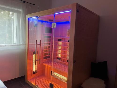 a glass cabinet with purple lights in a room at Neue moderne Ferienwohnung mit Infrarot Sauna und großen Garten in Hengersberg