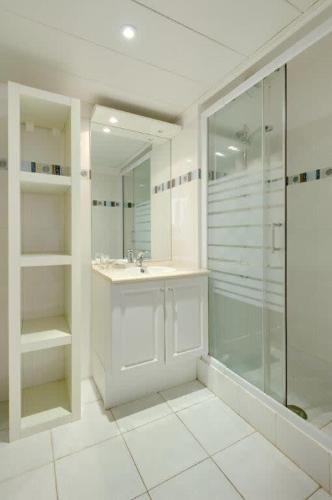 une salle de bain blanche avec un lavabo et une douche dans l'établissement Villa Kappas - B42 Promenade des Anglais, à Nice