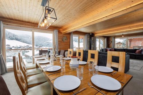 une salle à manger avec une longue table et des chaises dans l'établissement Chalet Le Saint Georges, Morzine, proche centre, à Morzine
