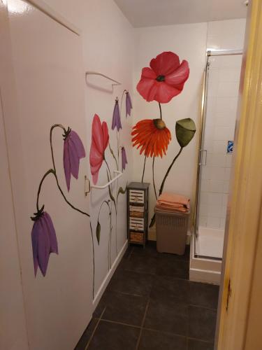 a bathroom with a painting of flowers on the wall at Cosy 2 bed cottage next to Fota Wildlife Park in Cork