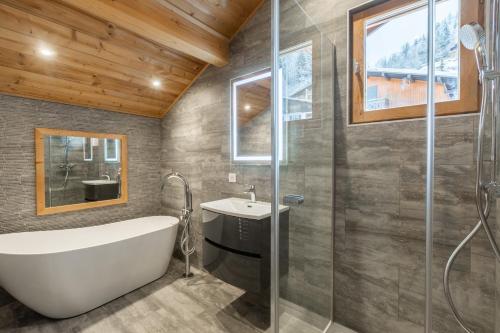 une salle de bain avec une baignoire, un lavabo et une douche dans l'établissement Chalet Le Saint Georges, Morzine, proche centre, à Morzine