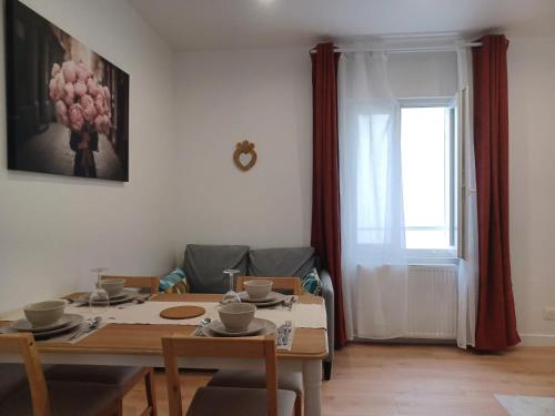 een eetkamer met een tafel en een raam bij La Demeure du Chevalier in Saint-Cyr-lʼÉcole