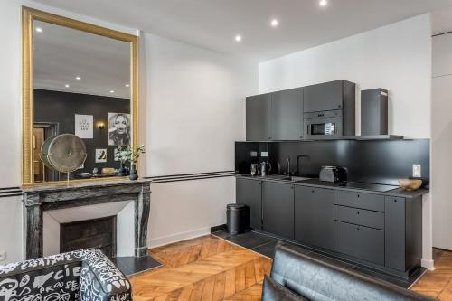 un salon avec une cuisine et une cheminée dans l'établissement V2D Vivid Elegance near Palais Royal 4P, à Paris