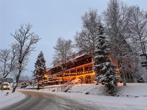 a building on a street covered in snow at Wellness Penzion Zora Family in Tatranská Lomnica