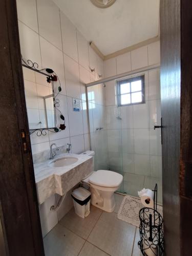 a bathroom with a sink and a toilet and a mirror at Pousada Mirante Imperial in Tiradentes