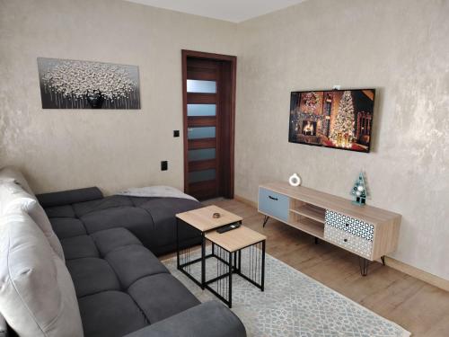 a living room with a couch and a table at КЪЩА ЗА ГОСТИ ГРОШЪ in Dobrinishte