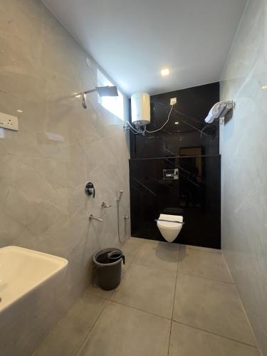 a bathroom with a white toilet and a sink at Arudra Residency in Tiruvannāmalai
