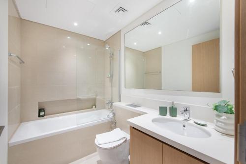 a bathroom with a sink and a toilet and a tub at Free housekeeping visits during your stay - StayShort - Stylish Cozy 3-Bedroom Apartment with Harbour Views in Dubai Creek Harbour in Dubai