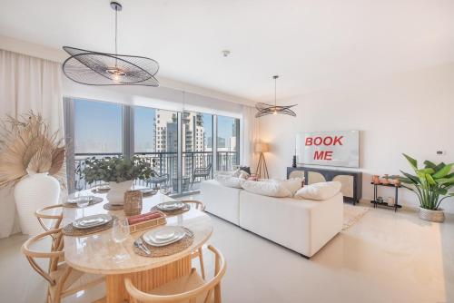 a living room with a white couch and a table at Free housekeeping visits during your stay - StayShort - Stylish Cozy 3-Bedroom Apartment with Harbour Views in Dubai Creek Harbour in Dubai