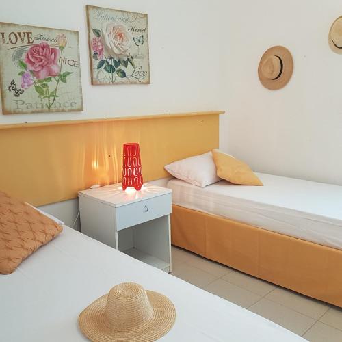 ein Schlafzimmer mit zwei Betten und einem Tisch mit Lampe in der Unterkunft Sirleo house in Torre dell'Orso