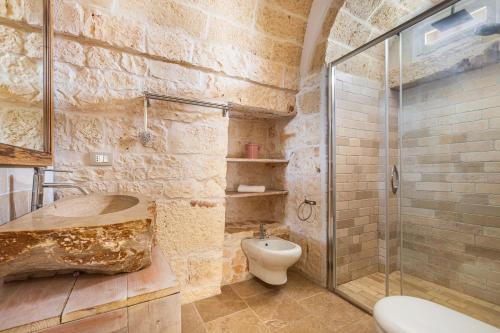 ein Badezimmer mit Toilette und Glasdusche in der Unterkunft Trullo Isabell by Perle di Puglia in San Vito dei Normanni
