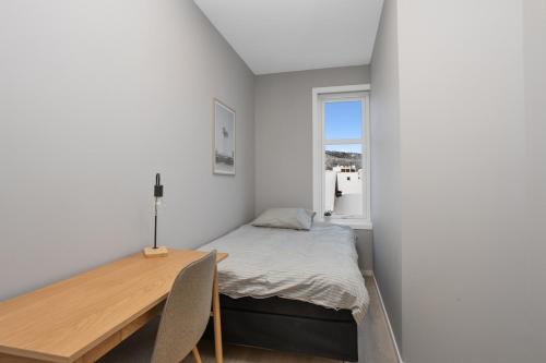 a bedroom with a bed and a desk and a window at 4 bedroom Penthouse Appartment, Right On The Mainstreet in Kongsberg