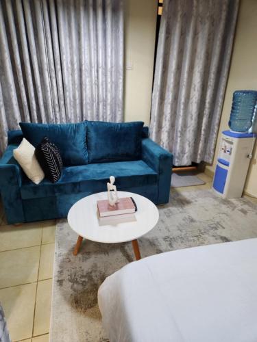 a living room with a blue couch and a table at The Haven in Ongata Rongai 