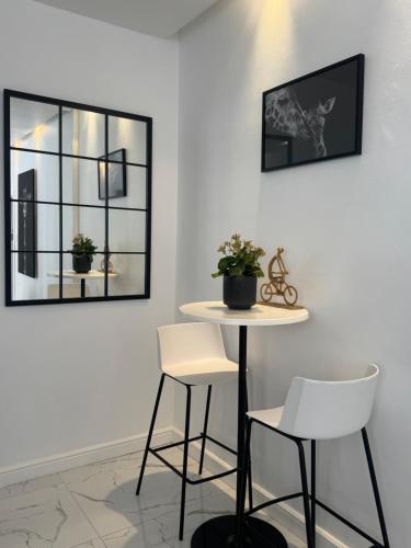 a table and two white chairs in a room at Luxurious Apartment in Cape Town