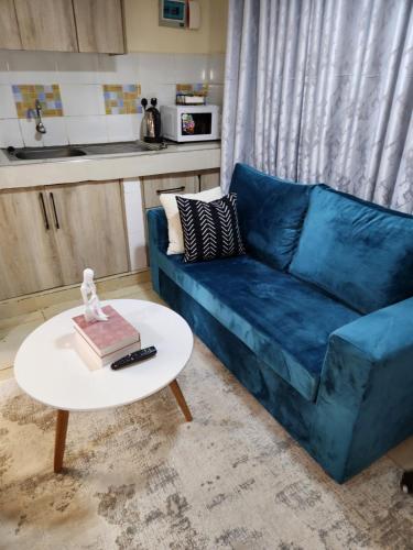 a blue couch in a living room with a table at The Haven in Ongata Rongai 