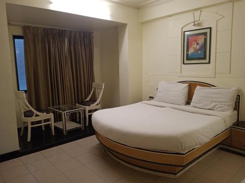 a bedroom with a bed and a table and chairs at Indiana Classic in Jaipur