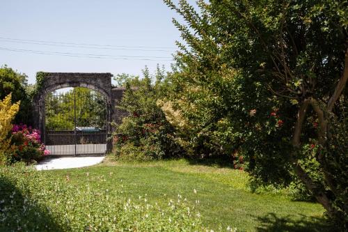 an archway in a garden with grass and flowers at Maison Capdevielle in Jasses