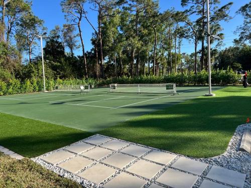 a tennis court with two tennis rackets on it at Luxury Family Pool, Jacuzzi, 2 Pickleball Court, Ping Pong Table Very Private Home Sleeps 8 in Naples