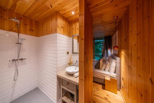 a bathroom with a shower and a sink in a room at TreeHouses Noszvaj in Noszvaj