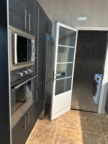 una cucina con forno a microonde e una porta che conduce a un corridoio di Playa Isomara a Puerto del Rosario