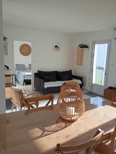 un salon avec une table, des chaises et un canapé dans l'établissement Maison proche de la plage, à La Brée-les-Bains