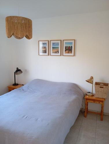 une chambre avec un lit et deux tableaux au mur dans l'établissement Maison proche de la plage, à La Brée-les-Bains