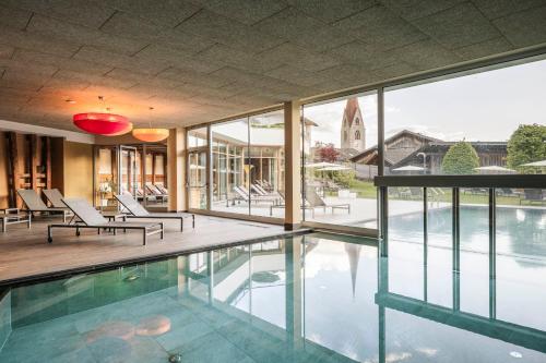 a house with a swimming pool with glass windows at Apartment Lodge Gasserhof in Bressanone