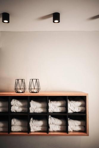a shelf filled with white towels on a wall at Apartment Lodge Gasserhof in Bressanone