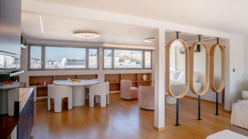 a kitchen and dining room with a table and mirrors at Apeiron Athena Residences in Athens