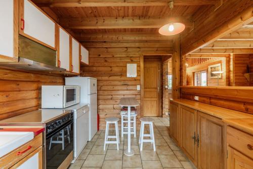 - une cuisine avec des appareils blancs et des murs en bois dans l'établissement Chalet Henri, Montriond ideal familles, à Montriond