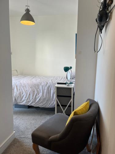 a bedroom with a bed with a chair and a table at Cliftonville House in Whitstable