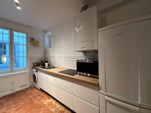 a kitchen with a refrigerator and a stove top oven at Maison Privée Saint-Germain-des-Prés in Paris