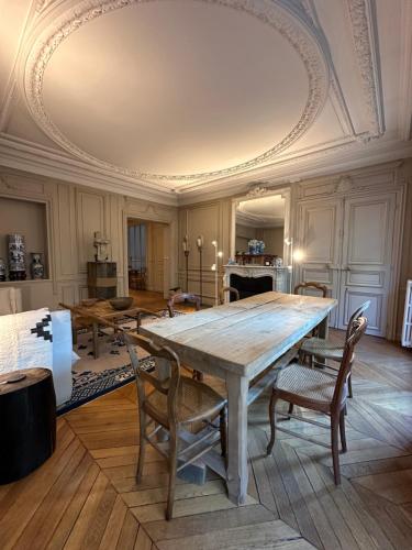 a dining room with a large wooden table and chairs at Maison Privée Saint-Germain-des-Prés in Paris